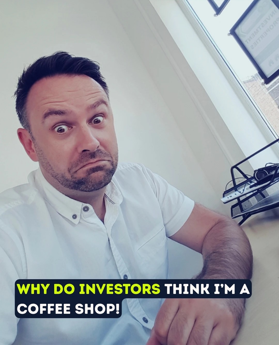 Paul pulling a face at his desk, captioned: why do investors think I'm a coffee shop